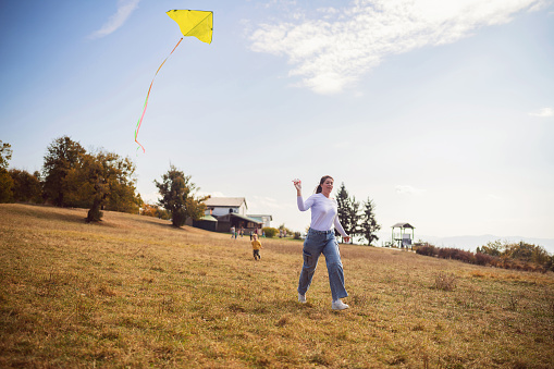 Mom flying a kite with her son.