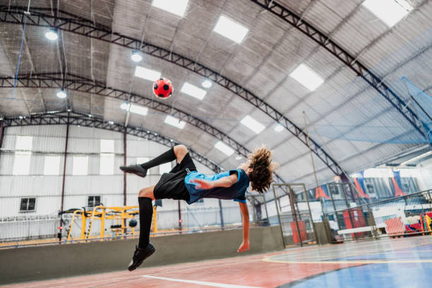 Boy doing a bicycle kick at a sports court