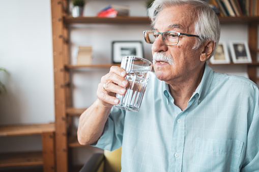 Portrait of senior man drinking water