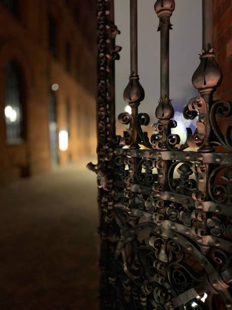 istock a black gate in front of a building at night time 1755795808