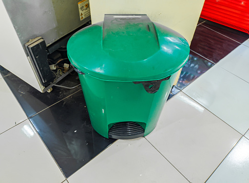 Small green trash can in hospital cafeteria