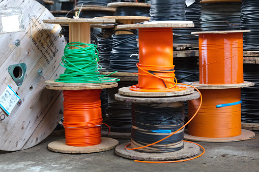 Spools of internet data cable fiber in warehouse.