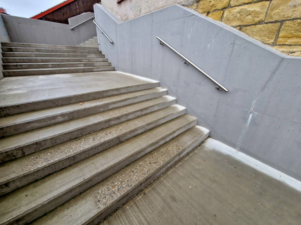 istock a staircase with concrete sides at a public building. the safe staircase has two handrails, one with a reduced height for children under 12 at the entrance to the school, brick, black, red. forgery 1755818462