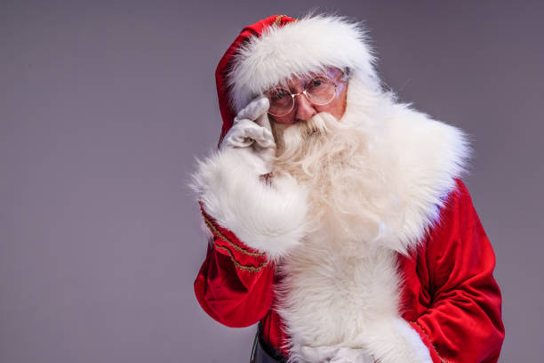 istock Real old Santa Claus looking at the camera, posing on a studio background. Merry Christmas and Happy New Year! Copy space. Xmas sale 1755819740