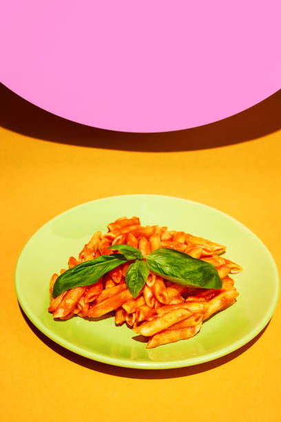 istock Delicious pasta, penne with tomato sauce and basil decorations over bright colorful background. Restaurant menu 1755825257