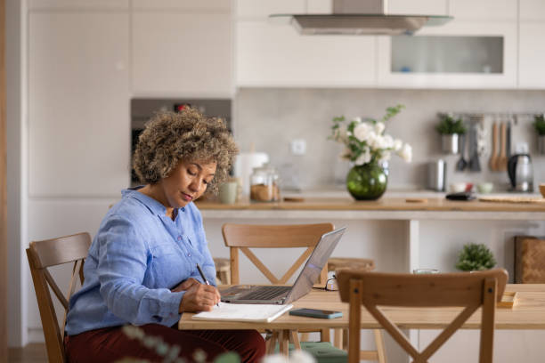 istock Businesswoman taking notes while working on laptop at home office. 1755834812
