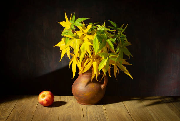 Still life with a ceramic vase and an apple