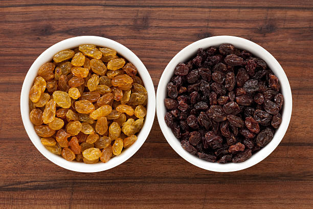 Raisins varieties Two bowls containing the light and dark raisins varieties raisin stock pictures, royalty-free photos & images