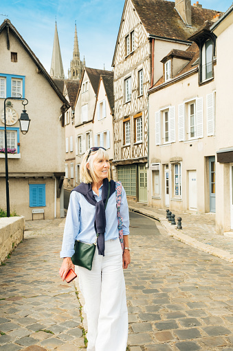 Female tourist at Pont Bouju in the town of Chartres, south west of Paris, France. The twin spires of the cathedral are in the background.