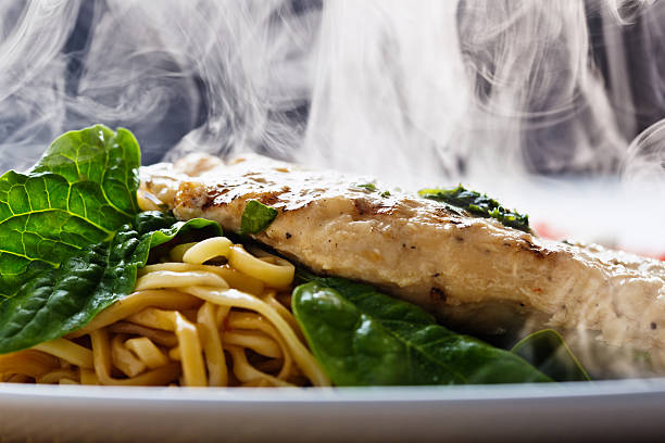 Steaming seared chicken breast with pesto, noodles and spinach