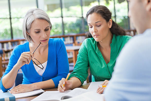 istock Group of people researching something together in library 175588312