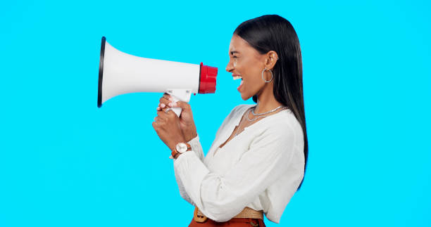 istock Megaphone communication, studio and woman scream, angry speech or broadcast gender equality, justice revolution or rally. Government politics protest, sound or loud profile speaker on blue background 1755887398