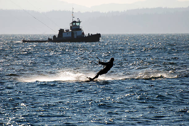 Kitesurfer and tugboat in Puget Sound Kitesurfer and tugboat in Puget Sound in Seattle WA kiteboarding stock pictures, royalty-free photos & images