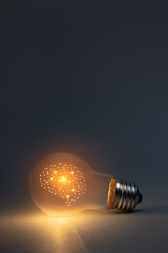 Artificial intelligence concept with brain symbol and glowing light bulb. This file is cleaned and retouched.
