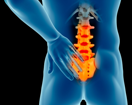 Anatomy of a man with his hand on lower back suggesting a possible low back pain. Isolated on a black background.