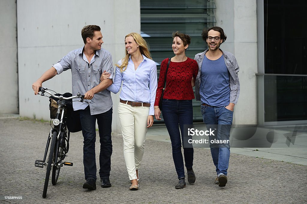 Cuatro adulto joven caminando hablar divirtiéndose - Foto de stock de Acera libre de derechos