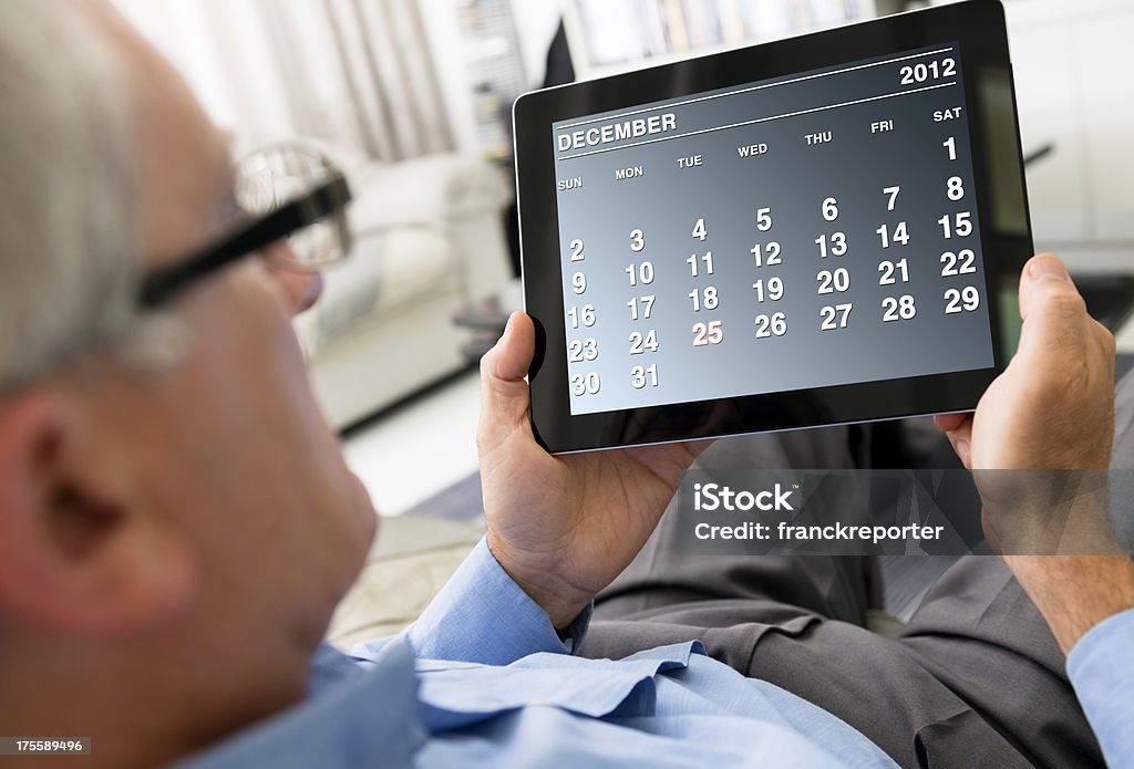 Homem segurando um tablet digital com calendário de dezembro de 2012 - Foto de stock de Calendário royalty-free