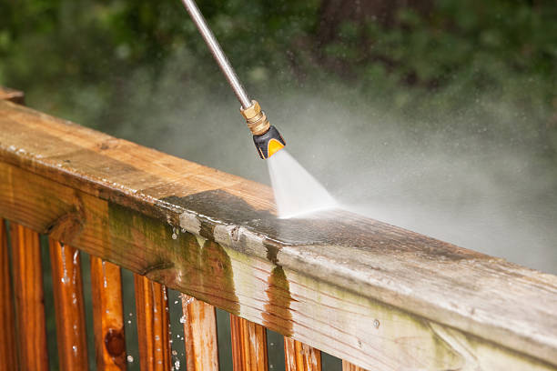 Pressure Washer Cleaning a Weathered Deck Railing stock photo
