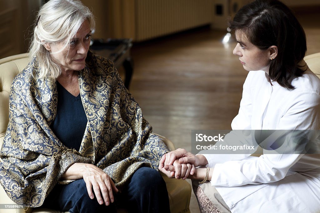Femme âgée au soin maison est l'attention de femme médecin - Photo de 60-64 ans libre de droits