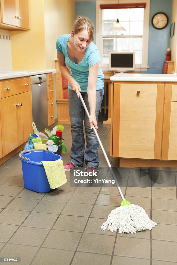 Mujer joven de limpieza Mopping en la cocina - Foto de stock de 20 a 29 años libre de derechos