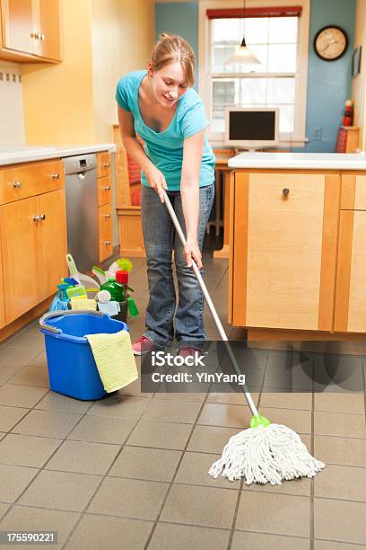 Mujer Joven De Limpieza Mopping En La Cocina Foto de stock y más banco de imágenes de 20 a 29 años - 20 a 29 años, Adulto, Adulto joven