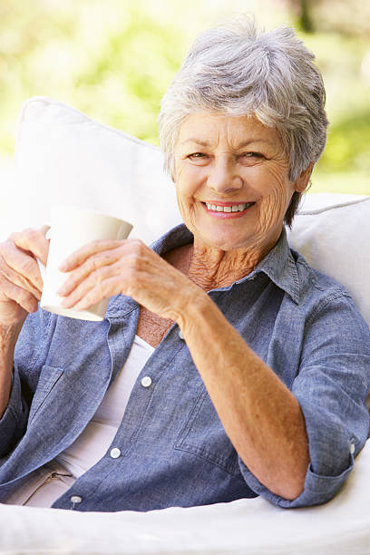 istock Happy Senior Woman Sitting On Sofa With Drink 175590745