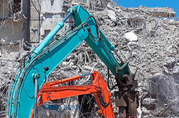 istock Two cranes breaking up concrete at demolition site 175590784