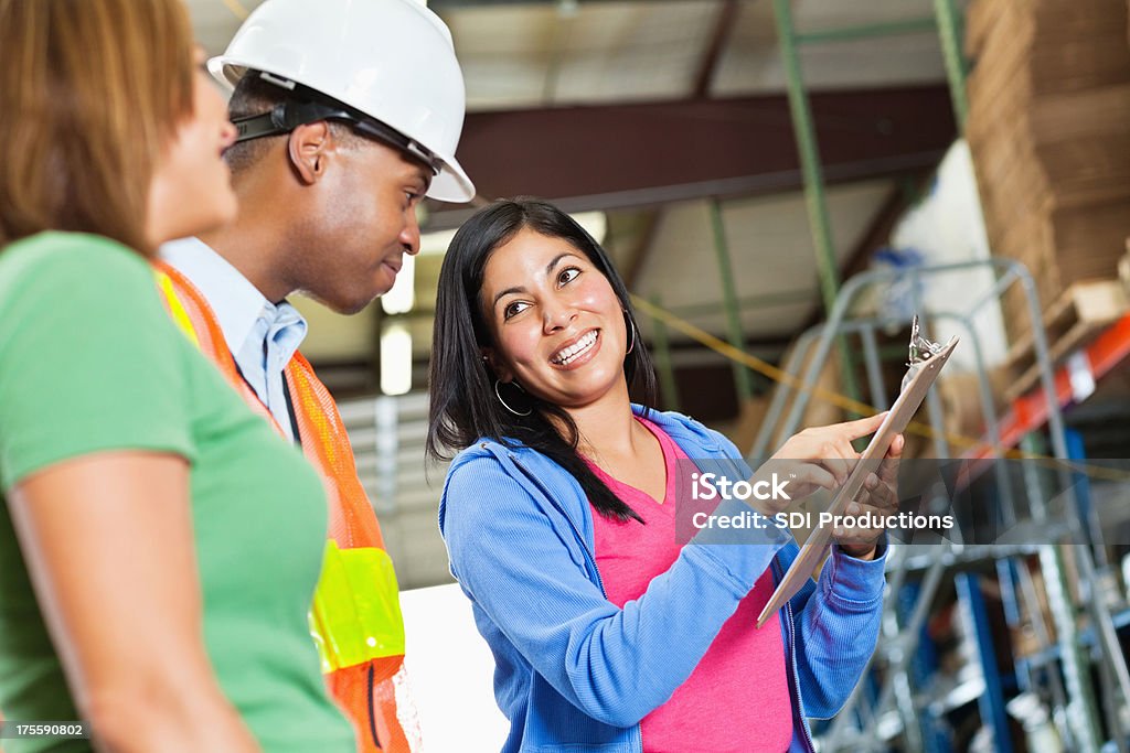 Manager inventario di andare oltre con i lavoratori in un magazzino - Foto stock royalty-free di Corso di formazione