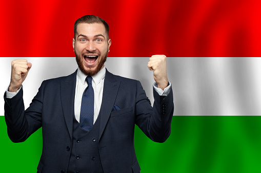 Hungarian happy businessman on the background of flag of Hungary Business, education, degree and citizenship concept