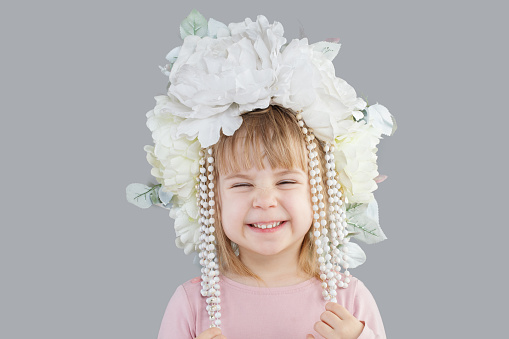 Cute laughing child baby girl in white flower hat portrait