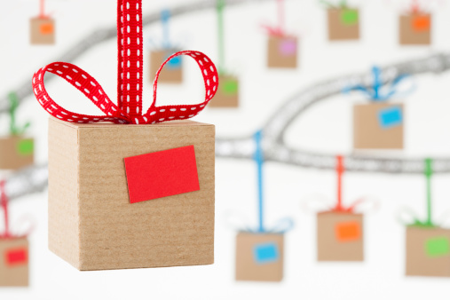 Cardboard gift boxes hanging from colourful ribbons with blank gift tags. Shallow depth of field, focus on the foreground. Similar versions also available.