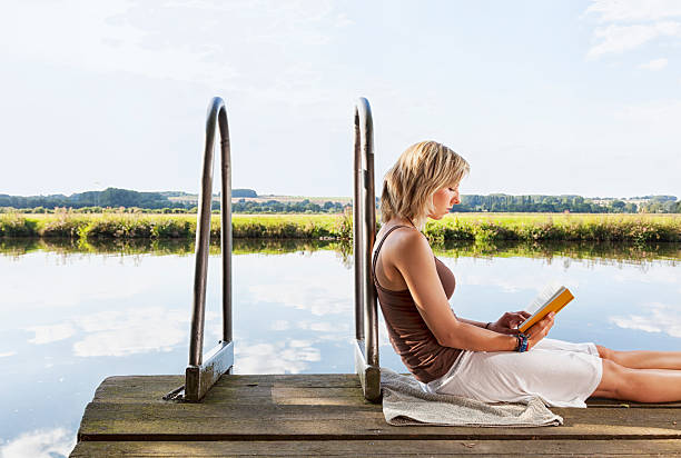 istock young woman reading book in summer 175592095