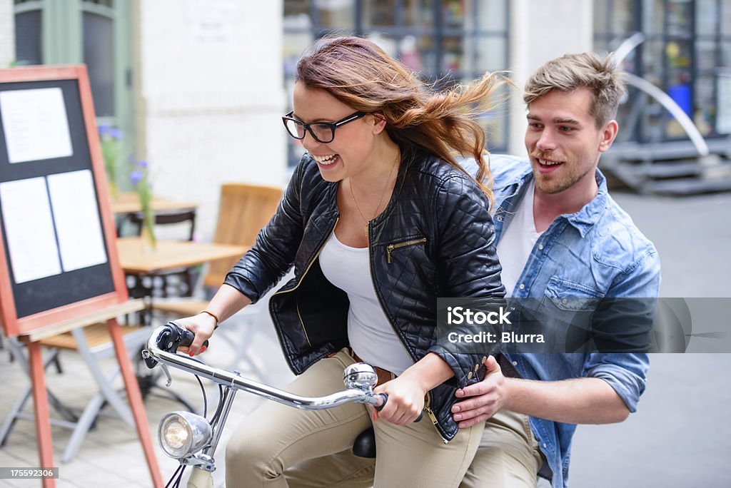 Young Couple on a Bicycle Young man and woman in love on a bicycle. Dating Stock Photo