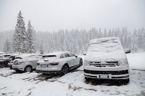 Accumulated snow depth in a parking lot in Misurina, Province of Belluno. Cars covered with snow, winter day in Dolomites; Auronzo di Cadore, Veneto, Italy