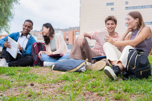 istock Multiracial group of college students sitting together on campus lawn 1755934486
