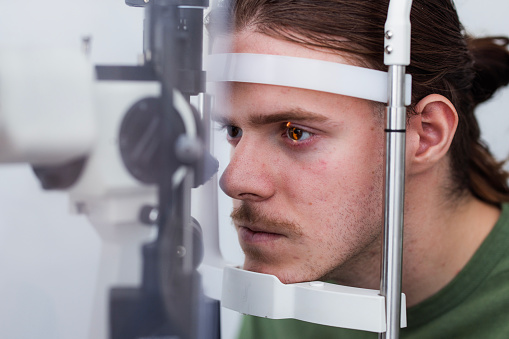 Man having his eye structures examined by a special optometrist equipment