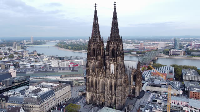Grand Cologne Cathedral Overlooks City Skyline and Rhine River Bank -  Aerial Orbit