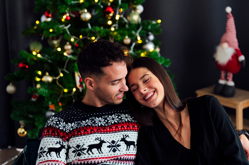 Happy young couple smiling at christmas at home