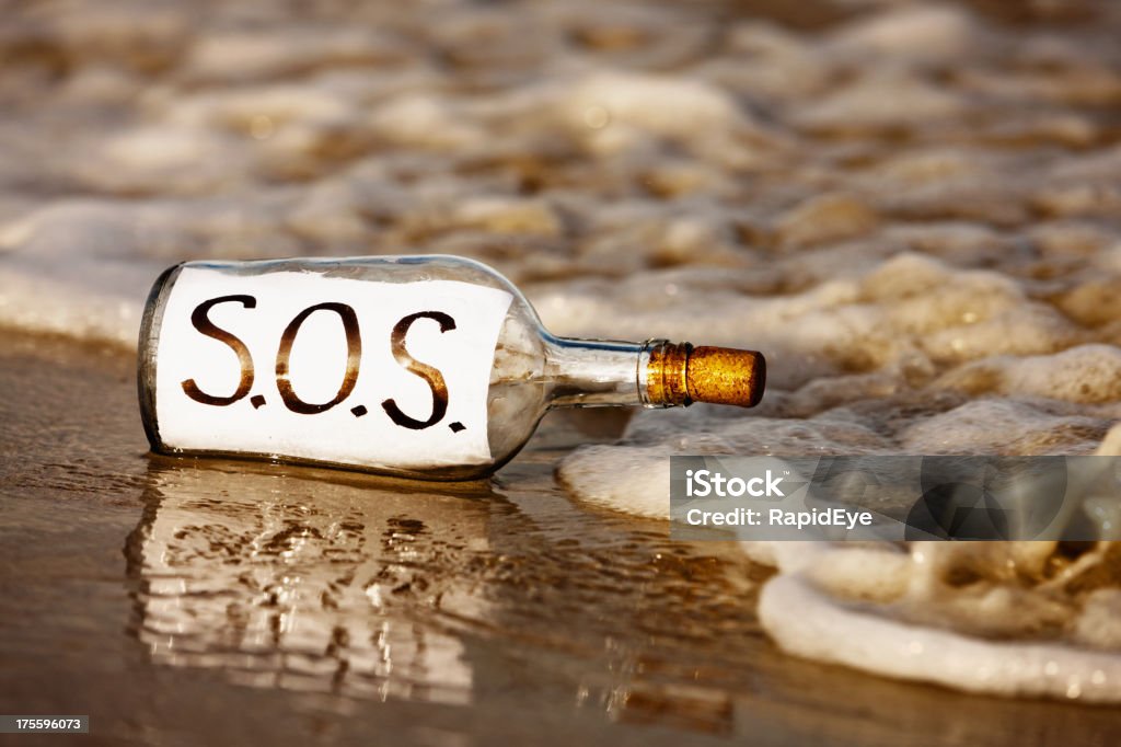 Close-up di SOS messaggio in bottiglia al litorale - Foto stock royalty-free di Acqua