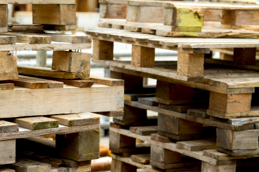 A stack of wood pallets. Selective focus on left pallets.