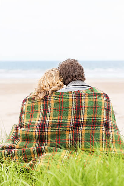 istock Couple Wrapped In Blanket At Beach 175596359