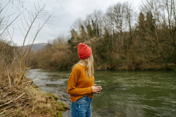 Photo of a mid adult woman spending her extended weekend in nature, on the properti that's over looking on a beautiful river