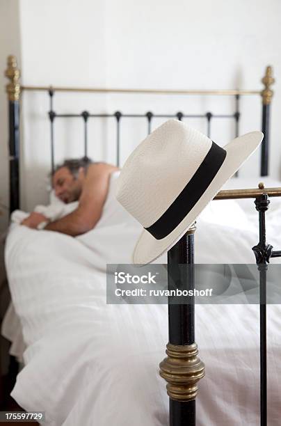 Текущие Человек С Шляпу На Bedpost — стоковые фотографии и другие картинки Вертикальный - Вертикальный, Взрослый, Кровать