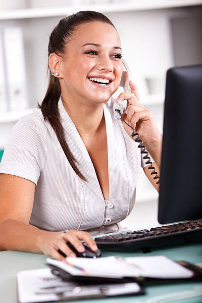 istock Young businesswoman talking on telephone and using computer 175597733