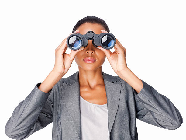 mujer de negocios mirando a través de binoculares aislado - mirando através fotografías e imágenes de stock