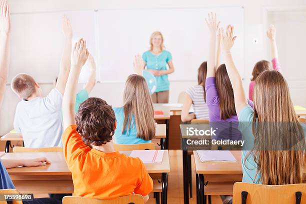 Pupils In Classroom Responding To The Teachers Question Stock Photo - Download Image Now