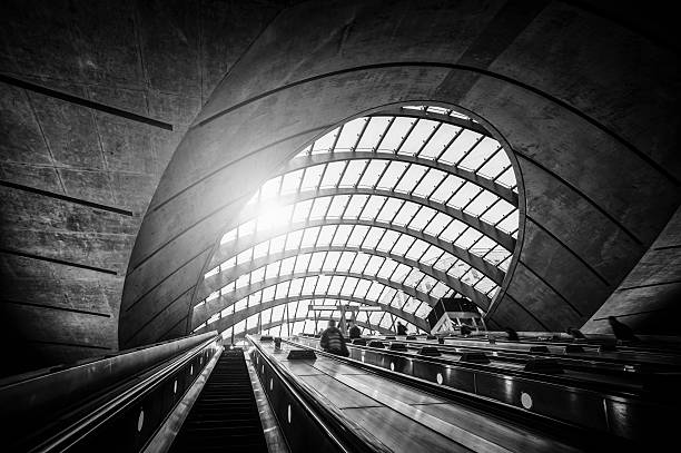 personen auf rolltreppe zur u-bahn-station canary wharf, london - london england vanishing point underground diminishing perspective stock-fotos und bilder