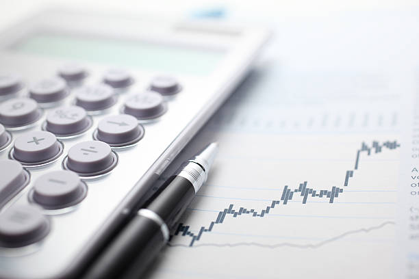 Business Planning Calculator and ballpoint pen on stock market data chart. planned economy stock pictures, royalty-free photos & images