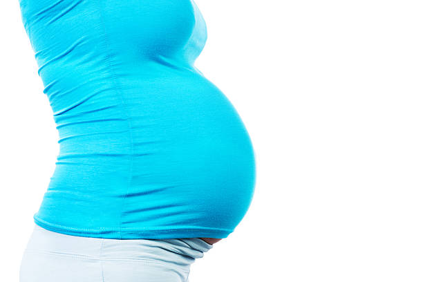 Pregnant vibes. Pregnant woman in the park. Close up.
