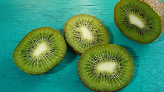 kiwi fruit on a turquoise wooden board. sliced ​​kiwi fruit. healthy food theme, healthy lifestyle theme, diet theme, healthy fruit theme